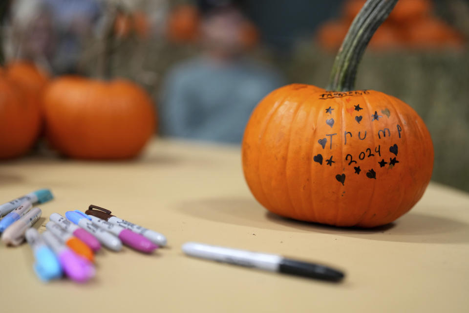 Pumpkins are decorated for former President Donald Trump during a campaign rally, Monday, Oct. 16, 2023, in Clive, Iowa. (AP Photo/Matthew Putney)