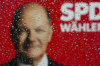 European Election campaign poster of the Social Democratic Party, SPD, with a portrait of German Chancellor Olaf Scholz and the slogan 'Vote SPD' is photographed through a window covered with rain drops in Berlin, Germany, Thursday, May 30, 2024. The European elections will take place form June 6 to June 9. German politics are in a disgruntled, volatile state as the country's voters prepare to fill 96 of the 720 seats at the European Parliament on June 9, the biggest single national contingent in the 27-nation European Union. It's the first nationwide vote since center-left Chancellor Olaf Scholz took power in late 2021. (AP Photo/Markus Schreiber)