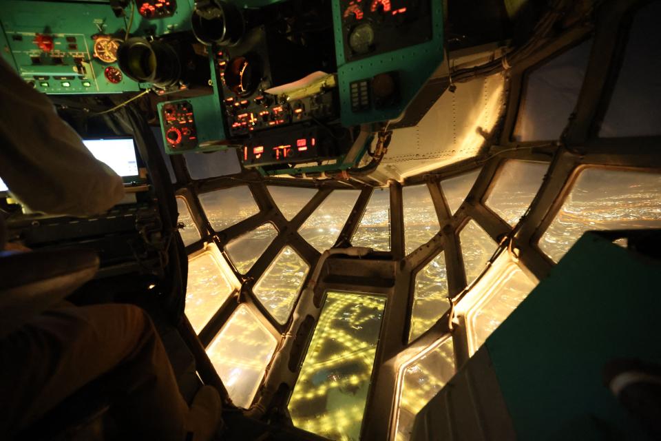 A view from the glass nose of a Ilyushin Il-76 aircraft as it lands in Abu Dhabi at night.