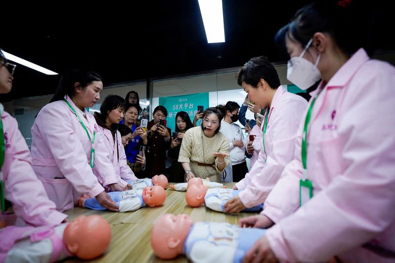 FILE PHOTO: Women take part in a nursing skills class for confinement carers, in Shanghai
