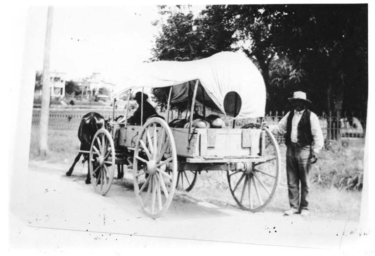 An African American man stands near a wagon loaded with watermelons on June 19, 1900 in Texas.