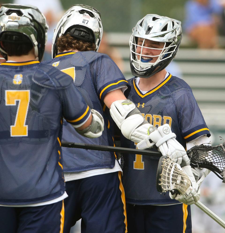 Sanford's Blake Bearley (right) celebrates his goal as the Warriors close to within one goal, down 8-7, against Tower Hill in the fourth quarter of the Hillers' 9-8 overtime win at Tower Hill School Thursday, April 6, 2023.