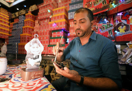 Mohamed Gamal works on a lantern with a portrait of Abla Fahita, a puppet television host, in Cairo, Egypt May 16, 2017. Picture taken May 16, 2017. REUTERS/Mohamed Abd El Ghany