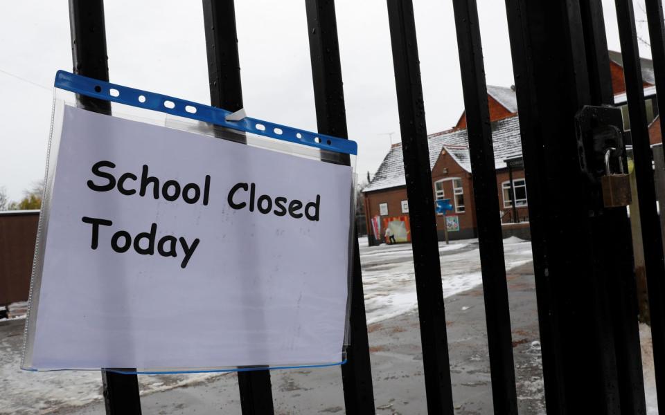 A closed sign hangs on the gate of a school following snow fall - REUTERS