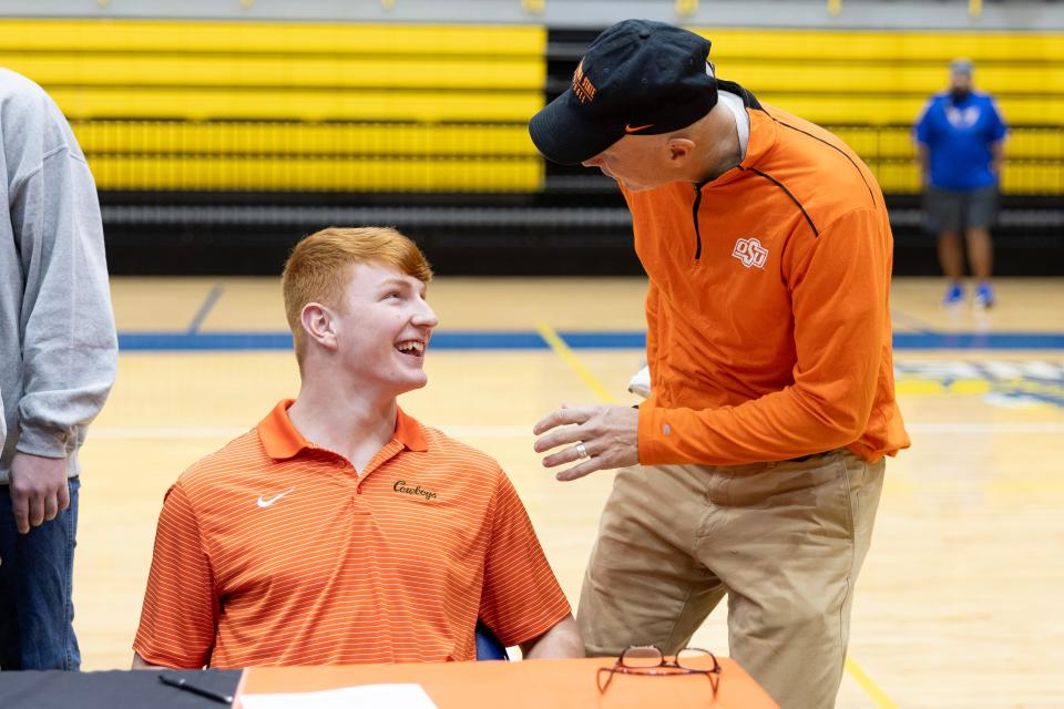 OSU football commit Josh Ford, left, celebrates with his father, Ray Ford, at a signing day ceremony Monday at the Stillwater High School gym.