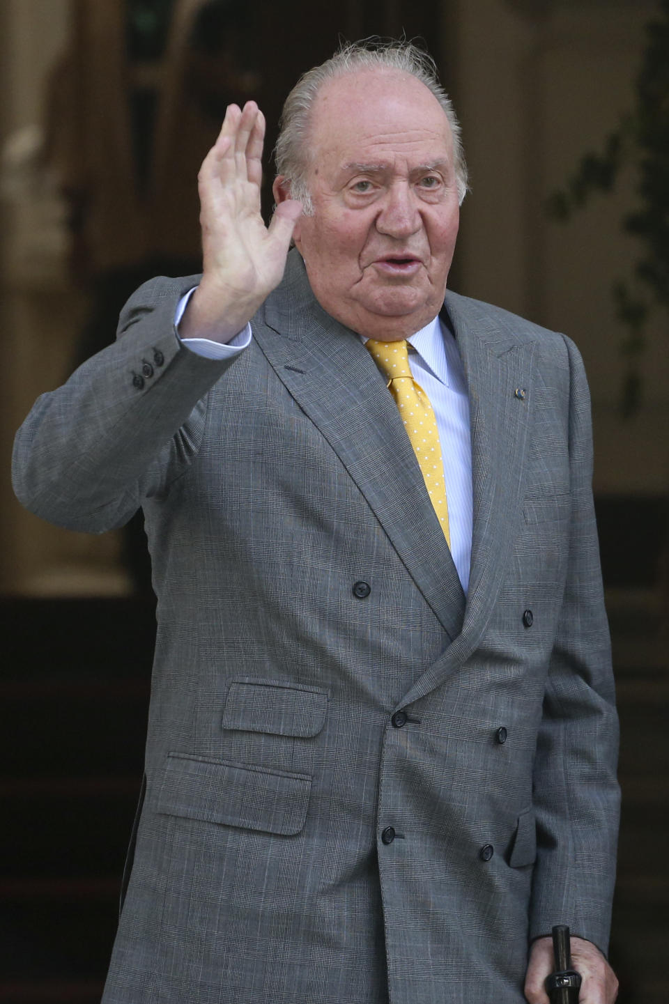 FILE - In this file photo dated Saturday, March 10, 2018, Spain's emeritus King Juan Carlos waves upon his arrival to the Academia Diplomatica de Chile, in Santiago. Spain's royal family’s website on Monday Aug. 3, 2020, published a letter from Spain’s former monarch, King Juan Carlos I, saying he is leaving Spain to live in another country, amidst a financial scandal. (AP Photo/Esteban Felix, FILE)
