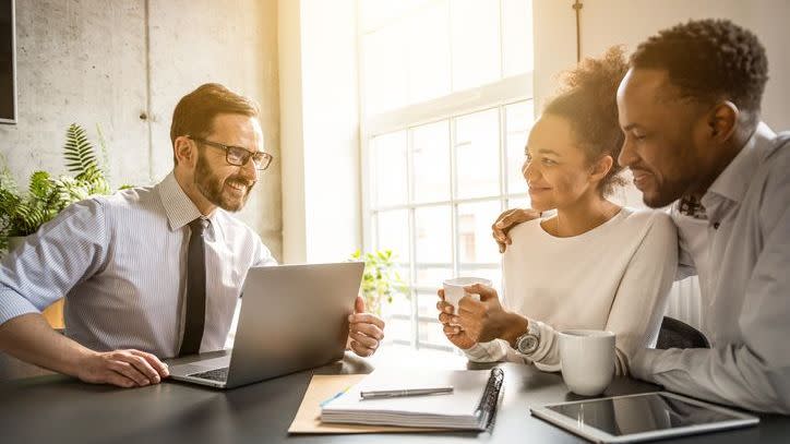 A financial advisor goes over his fee structure with two prospective clients. 