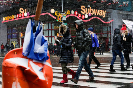People walk around Times Square as a cold weather front hits the region, in Manhattan, New York, U.S., December 30, 2017. REUTERS/Eduardo Munoz