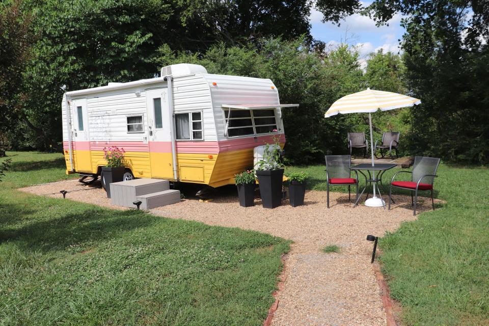 A Dolly Parton-themed RV on Airbnb with a small outdoor seating area next to it.