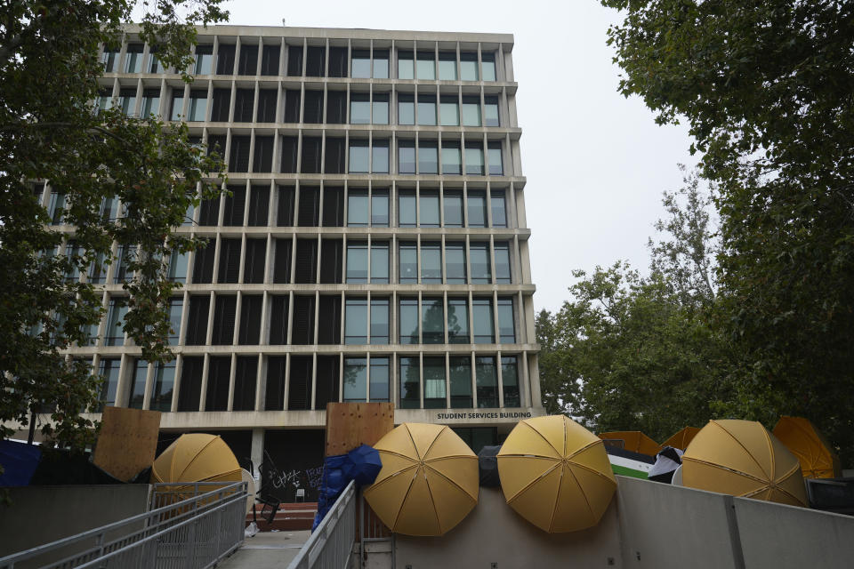 A barricade and graffiti are seen left by pro-Palestinian protesters at the Student Services Building at California State University, Los Angeles campus in Los Angeles, Thursday, June 13, 2024. A takeover of a building at the university by demonstrators protesting Israel's war against Hamas in Gaza ended early Thursday, leaving the facility trashed and covered with graffiti. (AP Photo/Damian Dovarganes)