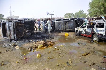 People gather at the scene of a suicide bombing at a bus station in Kano February 24, 2015. REUTERS/Stringer