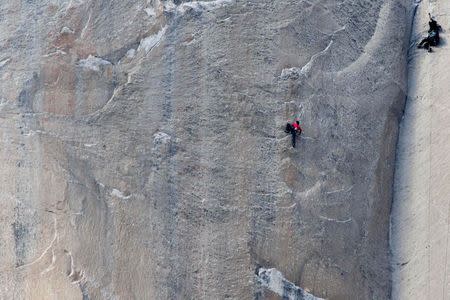 Climber Kevin Jorgeson (red shirt) climbs Pitch 18 of the Dawn Wall as a cameraman (R) records on the El Capitan rock formation in Yosemite National Park, California in this January 12, 2015 handout photo released to Reuters January 13, 2015.