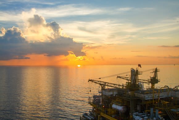 Offshore oil production platform at sunrise or sunset