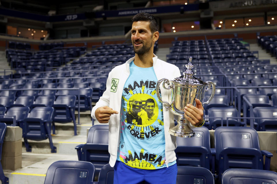 Novak Djokovic poses for the media with his 2023 US Open winner's trophy, wearing a shirt as a tribute to the late Kobe Bryant. / Credit: / Getty Images