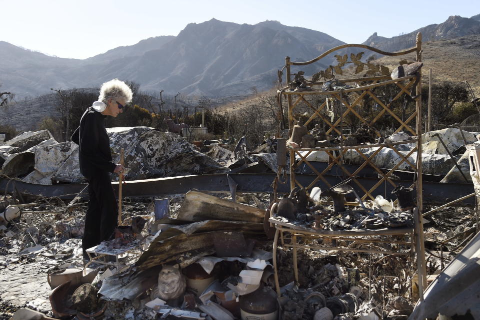 <p>Marsha Maus, who has lived in the Seminole Springs Mobile Home Park for 15 years, looks through her charred belongings, Sunday, Nov. 11, 2018, after wildfires tore through her neighborhood in Agoura Hills, Calif.<br>(Photo from Chris Pizzello, AP) </p>