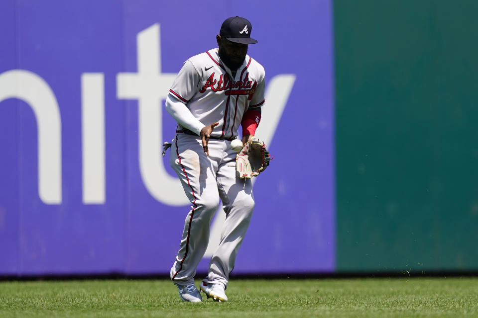 Atlanta Braves left fielder Marcell Ozuna fields a single by Philadelphia Phillies' Rhys Hoskins during the first inning of a baseball game, Wednesday, July 27, 2022, in Philadelphia. (AP Photo/Matt Slocum)