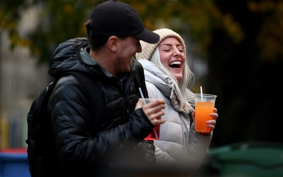 A couple drink from takeaway glasses outside a pub in the Grassmarket following last orders at 6pm on October 9, 2020 in Edinburgh - Jeff J Mitchell/Getty 