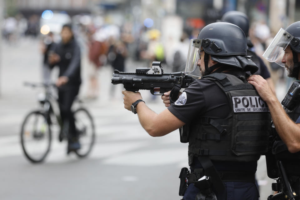 FILE - A police officer aims during a protest Friday, June 30, 2023 in Strasbourg, eastern France. In all, more than 3,600 people have been detained in the unrest across France since the death of Nahel on June 27, with an average age of 17, according to the Interior Ministry. The violence left more than 800 law enforcement officers injured, French courts are working overtime to process the arrests, including opening their doors through the weekend, with fast-track hearings around an hour long and same-day sentencing. (AP Photo/Jean-Francois Badias, File)