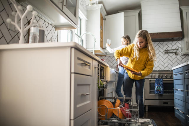 Woman Loading Washing Machine In Kitchen High-Res Stock Photo - Getty Images