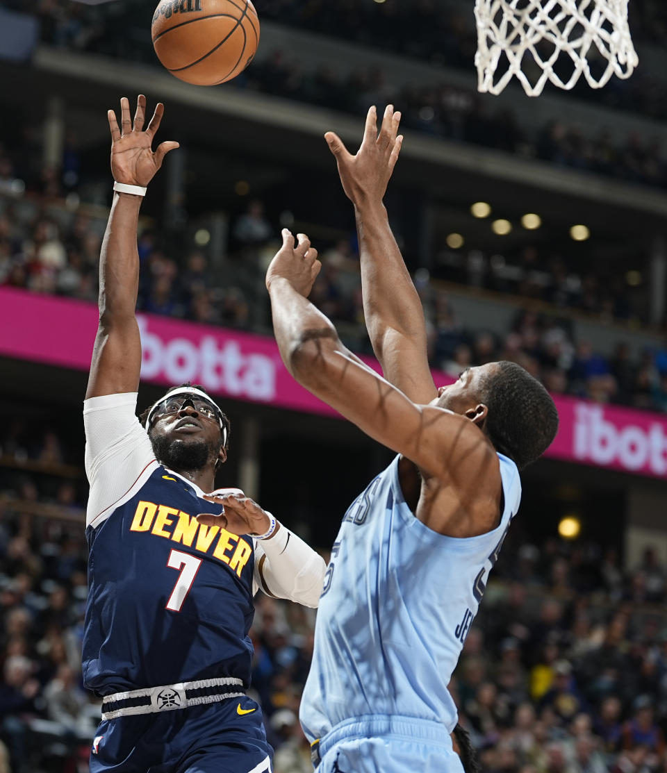 Denver Nuggets guard Reggie Jackson, left, goes up for a basket as Memphis Grizzlies center Trey Jemison defends in the first half of an NBA basketball game, Monday, March 25, 2024, in Denver. (AP Photo/David Zalubowski)