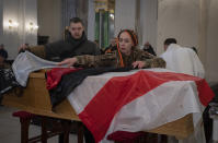 Friends use Belorussian flag to cover coffin of Eduard Lobau, a Belarusian volunteer soldier who was killed defending Donetsk region, in Kyiv, Ukraine, Saturday, Feb. 4, 2023. Eduard Lobau, a Belarusian who had been fighting for Ukraine since 2015, died from a shrapnel wound while hunting tanks with a Javelin. He is now at least the 15th Belarusian to have fallen fighting for Ukraine in the last year. (AP Photo/Efrem Lukatsky)