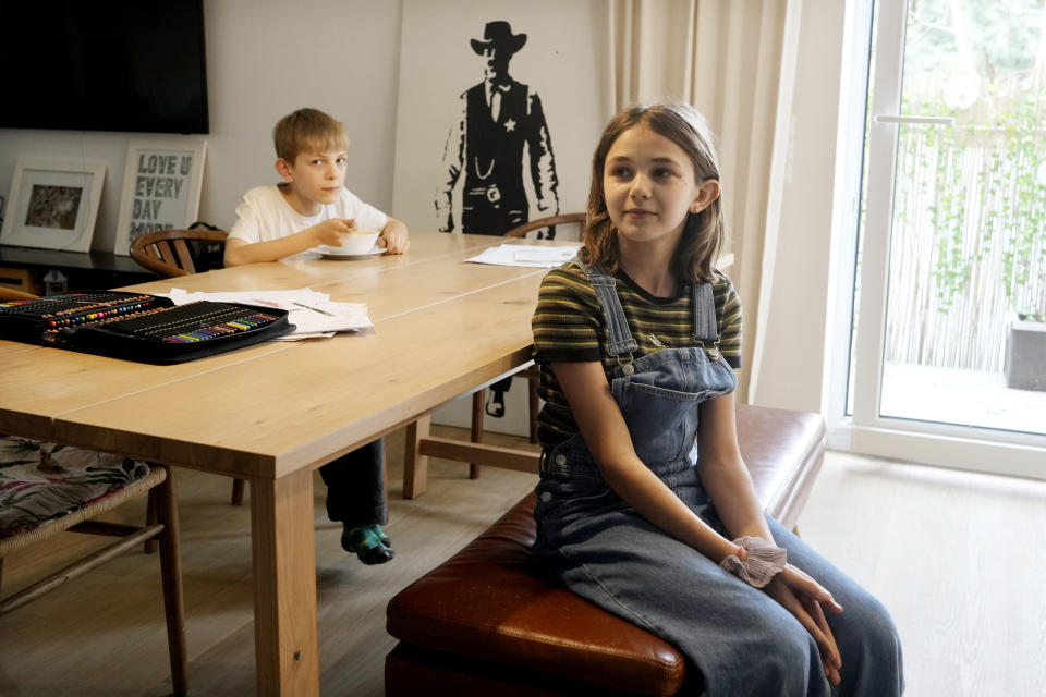 Ola Kozak, 11, right, and her younger brother Julian Kozak, 9, sit at the table where they used to do their homework at the family home in Warsaw, Poland, Friday April 5, 2024. Ola is happy that Poland's government has ordered strict limits on the amount of homework that teachers can impose on the lower grades, starting in April. Julian enjoyed doing his homework. (AP Photo/Czarek Sokolowski)