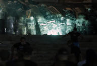 Protesters clash with riot police on the steps of the Serbian parliament during a protest in Belgrade, Serbia, Friday, July 10 2020. Hundreds of demonstrators tried to storm Serbia's parliament on Friday, clashing with police who fired tear gas during the fourth night of protests against the president's increasingly authoritarian rule. The protests started on Tuesday when President Aleksandar Vucic announced that Belgrade would be placed under a new three-day lockdown following a second wave of confirmed coronavirus infections. (AP Photo/Darko Vojinovic)