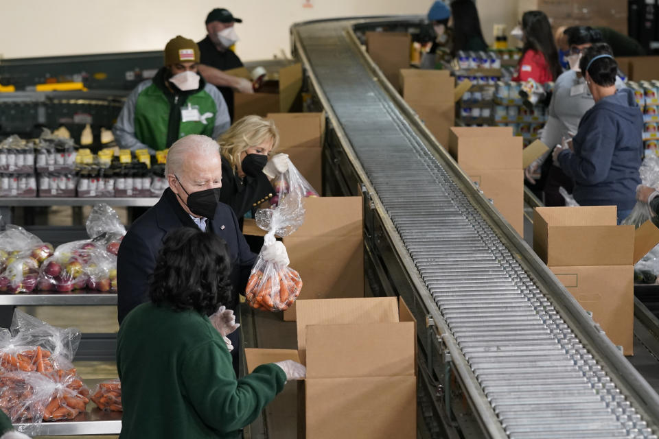 President Joe Biden and first lady Jill Biden pack produce while they volunteer at hunger relief organization Philabundance, Sunday, Jan. 16, 2022, in Philadelphia. (AP Photo/Patrick Semansky)