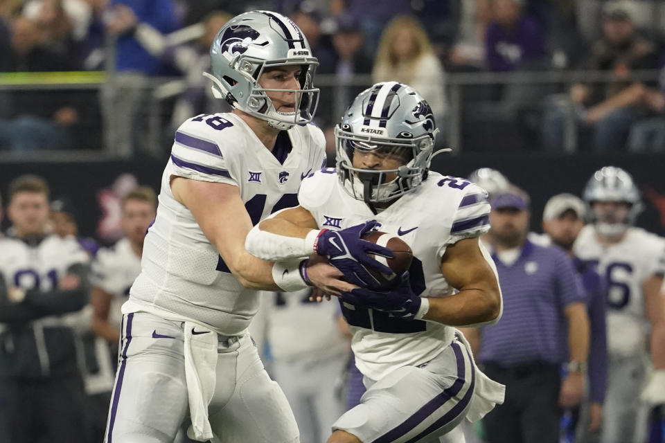 Kansas State quarterback Will Howard (18) hands off to running back Deuce Vaughn, right, in the first half of the Big 12 Conference championship NCAA college football game, Saturday, Dec. 3, 2022, in Arlington, Texas. (AP Photo/LM Otero)