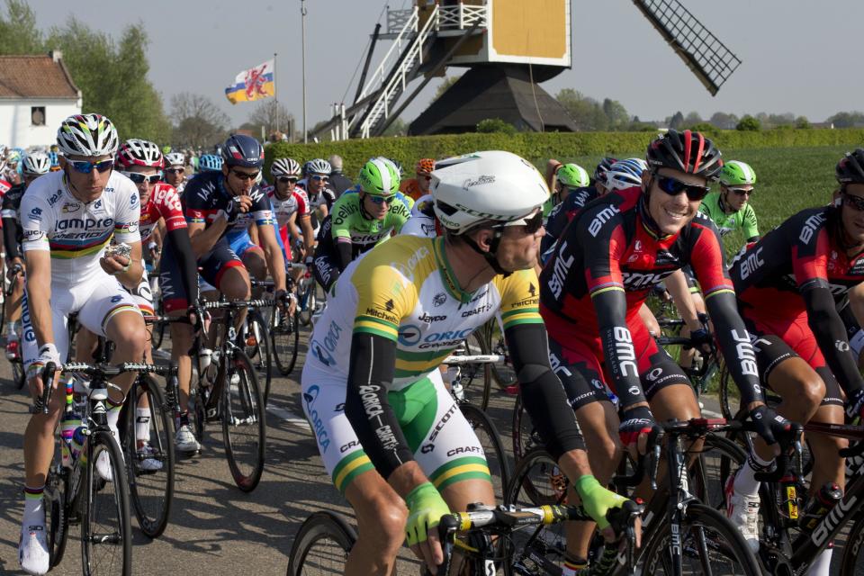 Belgium's Philippe Gilbert, second right smiling, and Portugal's Rui Alberto Costa, far left in white, pass a windmill near Oensel during the 49th edition of the Amstel Gold Cycling Race over 251.8 kilometers (156.5 miles) with start in Maastricht and finish in Valkenburg, southern Netherlands, Sunday, April 20, 2014. (AP Photo/Peter Dejong)