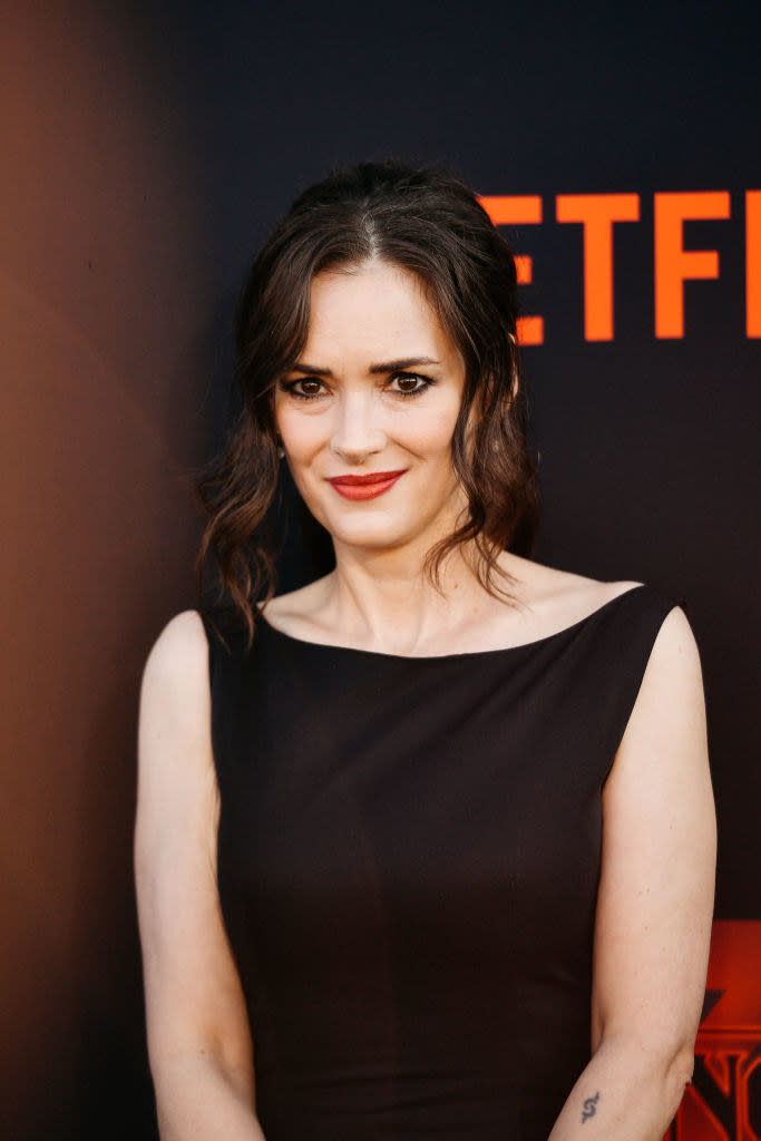 Winona in a more structured sleeveless dress with her hair up