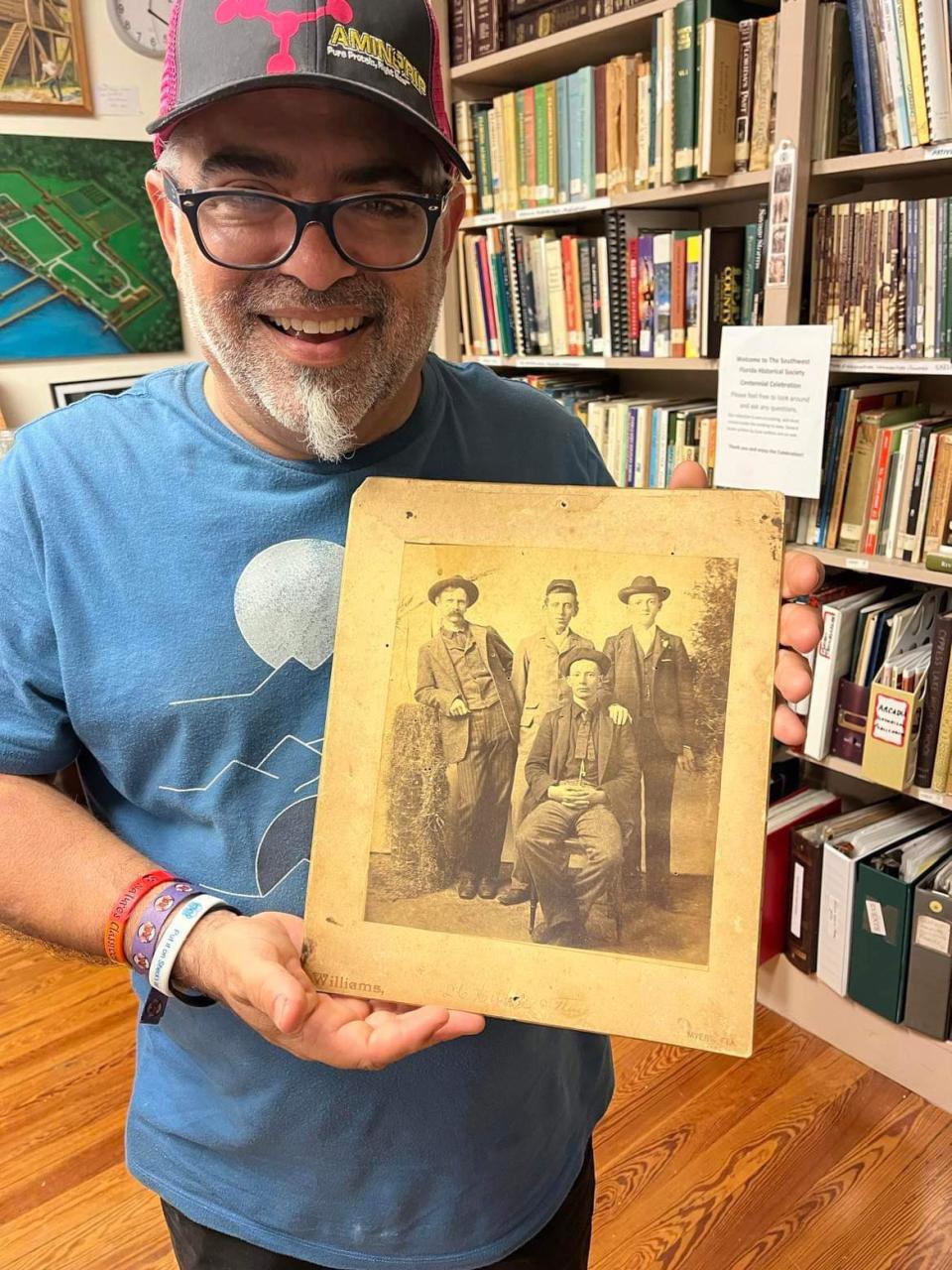 Cesar Becerra with a photo of 13-year-old Medford Kellum from the collection of the Southwest Florida Historical Society.