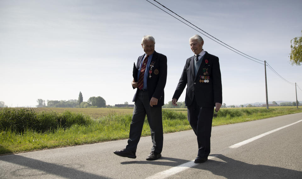 British RAF veteran George Sutherland, 98, right, leaves Lijssenthoek war cemetery with his son Alex Sutherland as he takes part in a VE Day charity walk to raise funds for Talbot House in Poperinge, Belgium, Friday, May 8, 2020. Sutherland's segment walked from the Lijssenthoek war cemetery to Talbot house to raise money for the club which is currently closed due to coronavirus lockdown regulations. The club, founded in 1915 was a place for British soldiers to rest during both the First and Second World Wars. (AP Photo/Virginia Mayo)