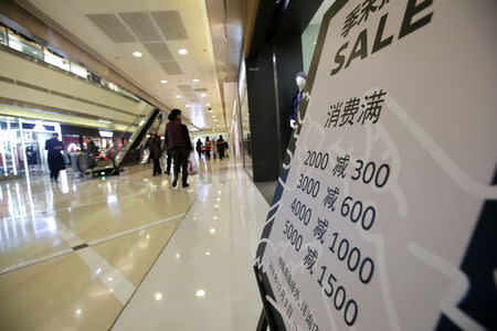 A poster promoting discounts is placed outside a store at a shopping center in Beijing, China December 14, 2018. REUTERS/Jason Lee