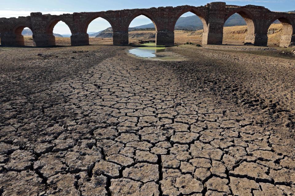 Part of the Guadiana river has dried up and gives way to dry land under the Puente de la Mesta medieval bridge in Villarta de los Montes, in the central-western Spanish region of Extremadura. Scientists say human-induced climate change is making extreme weather events including heatwaves and droughts more frequent and more intense.