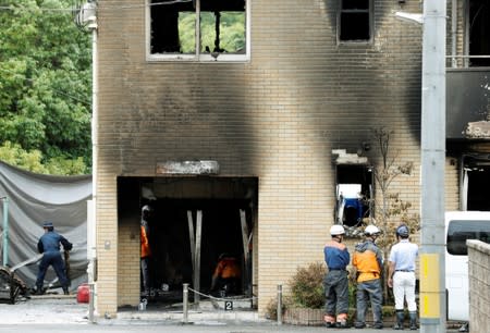 Firefighters work at the Kyoto Animation building which was torched by arson attack, in Kyoto