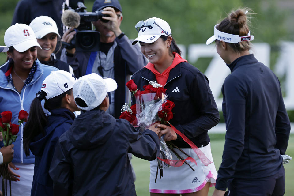 FILE - Rose Zhang, second from right, is given roses after winning the Mizuho Americas Open golf tournament on the second playoff hole, Sunday, June 4, 2023, in Jersey City, N.J. Her 4-hybrid on the 18th hole in a playoff enabled her to win in her pro debut. (AP Photo/Adam Hunger, File)