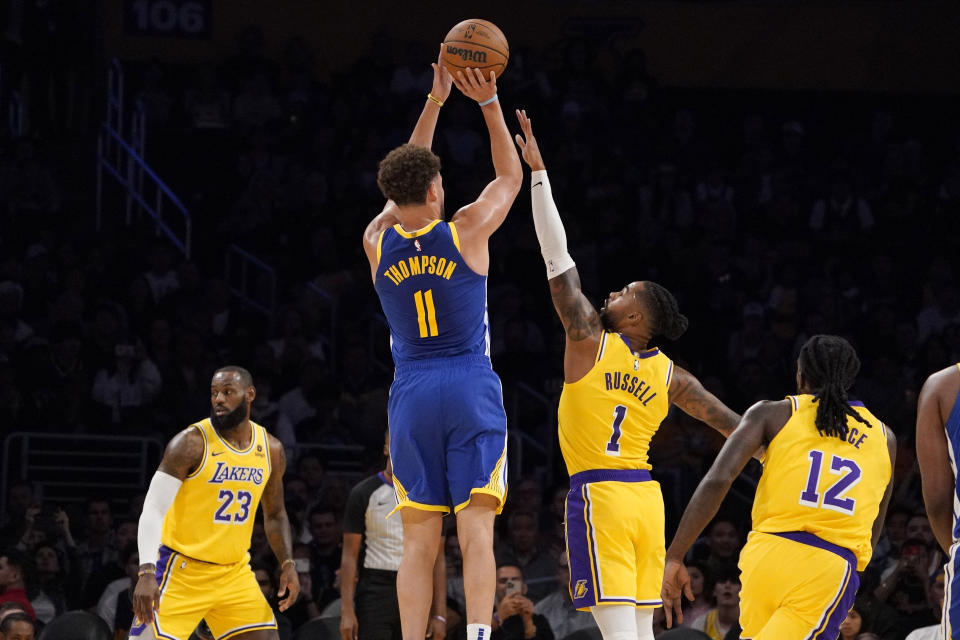 Golden State Warriors guard Klay Thompson, second from left, shoots as Los Angeles Lakers forward LeBron James, left, guard D'Angelo Russell, second from right, and forward Taurean Prince defend during the first half of an NBA preseason basketball game Friday, Oct. 13, 2023, in Los Angeles. (AP Photo/Mark J. Terrill)