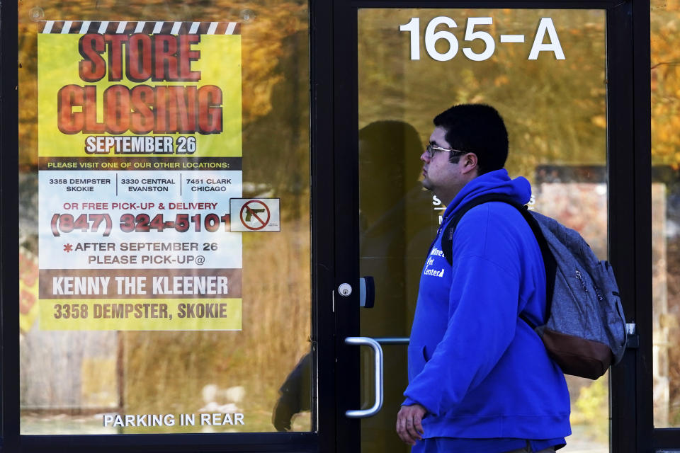 FILE - In this Friday, Nov. 6, 2020, file photo, a man walks past a closed store in Wilmette, Ill., amid the coronavirus pandemic. Responses to the coronavirus pandemic and police brutality dominated legislative sessions in 2020 and led to many new laws that will take effect in the new year. (AP Photo/Nam Y. Huh, File)