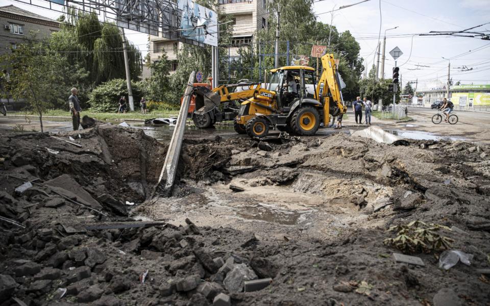 People clean up at the damaged sites after Russian missiles hit residential areas in Sloviansk - Metin Aktas/Anadolu Agency via Getty Images