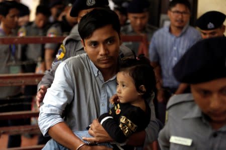 Detained Reuters journalist Kyaw Soe Oo carries his daughter Moe Thin Wai Zin while escorted by police to lunch break during a court hearing in Yangon, Myanmar June 11, 2018. REUTERS/Ann Wang