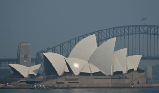 The Sydney Opera House and Harbour Bridge are seen through a smokey haze blanketing the city