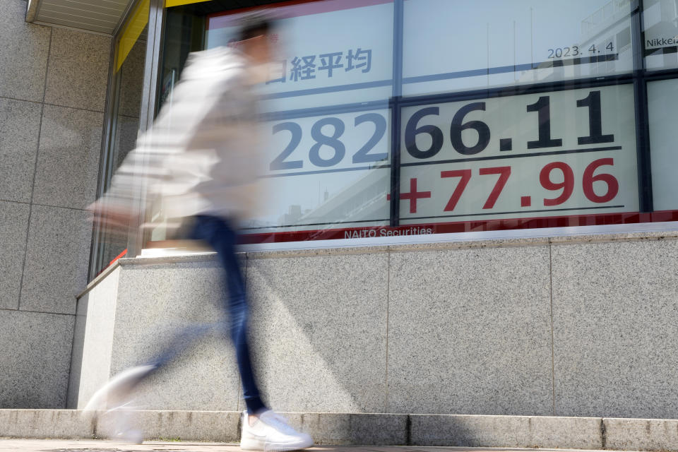 A person walks past an electronic stock board showing Japan's Nikkei 225 index at a securities firm Tuesday, April 4, 2023 in Tokyo. (AP Photo/Shuji Kajiyama)