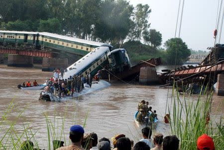 Pakistan Army soldiers and rescue workers gather at the site after a train fell in a canal, near Gujranwala, Pakistan, July 2, 2015. REUTERS/Stringer