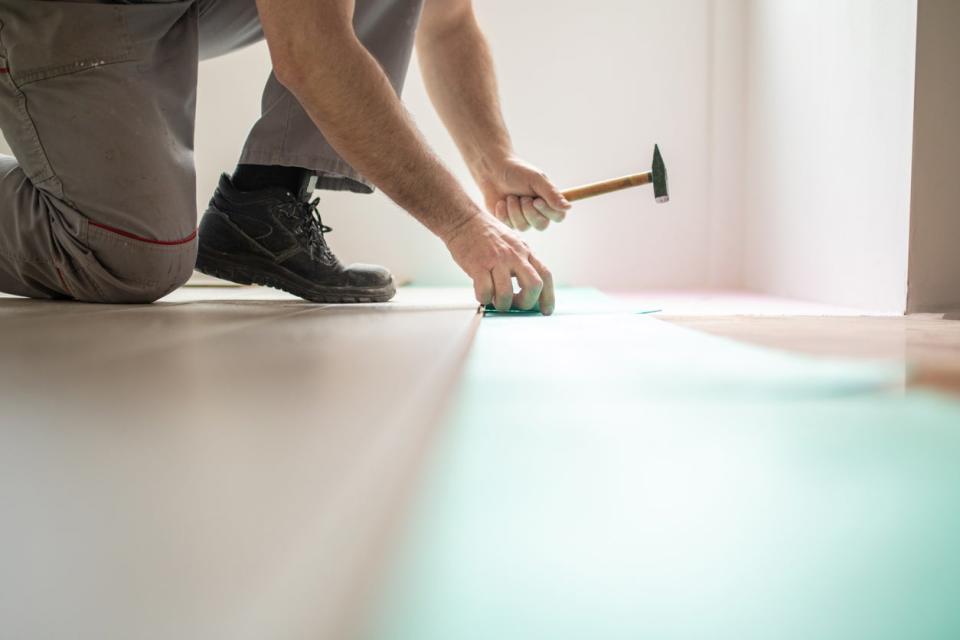 Man Installing new laminate wood flooring.