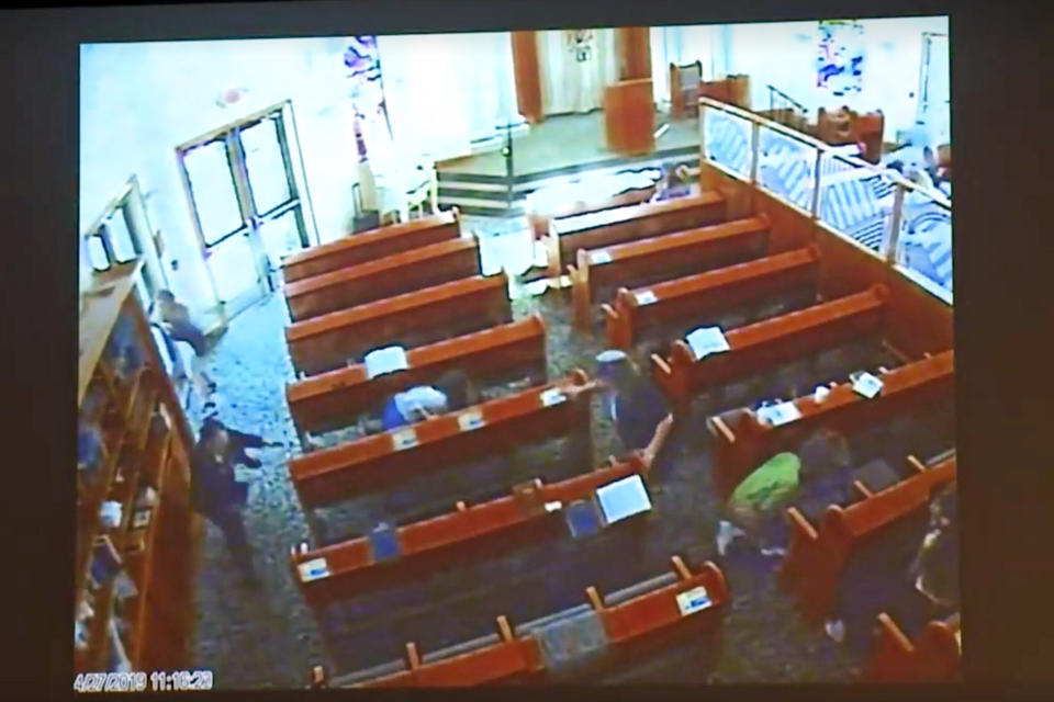 This April 27, 2019 photo from surveillance video at the Chabad of Poway, shown as evidence in the preliminary hearing of John T. Earnest, shows people diving for cover during during what authorities say is Earnest's rampage on the synagogue in Poway, Calif., in court in San Diego, Calif. on Thursday, Sept. 19, 2019. A woman was killed and three other people were wounded in the attack. Earnest has pleaded not guilty to murder, attempted murder and arson tied to a mosque fire. (Chabad of Poway/San Diego Superior Court via AP)