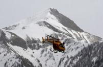 A rescue helicopter from the French Securite Civile flies over the French Alps during a rescue operation near the crash site of an Airbus A320, near Seyne-les-Alpes, March 24, 2015. REUTERS/Jean-Paul Pelissier