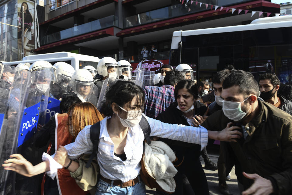 Turkish police officers, in riot gear, and wearing face masks for protections against the spread of the coronavirus, scuffle with protesters during a demonstration in Istanbul, Tuesday, June 2, 2020, against the recent killing of George Floyd in Minneapolis. (AP Photo/Omer Kuscu)