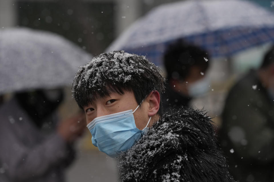 A man lines up for COVID-19 test as it snows on Thursday, March 17, 2022, in Beijing. A fast-spreading variant known as "stealth omicron" is testing China's zero-tolerance strategy, which had kept the virus at bay since the deadly initial outbreak in the city of Wuhan in early 2020. (AP Photo/Ng Han Guan)