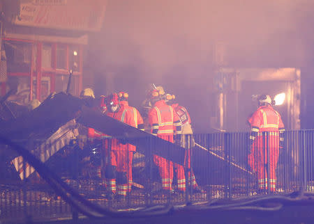 Members of the emergency services move debris at the site of an explosion which destroyed a convenience store and a home in Leicester, Britain, February 25, 2018. REUTERS/Darren Staples